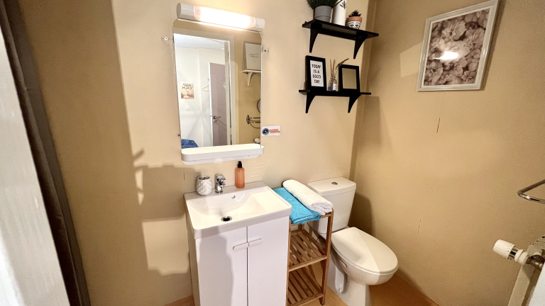 Une salle de douche avec des toilettes et un chauffage assurant un accueil confortable