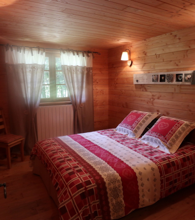 Chambre en bois, lit double, commode de rangement,fentre donnant sur des arbres, aucun vis  vis