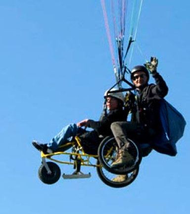 Parapente en bi-place avec une personne en fauteuil roulant