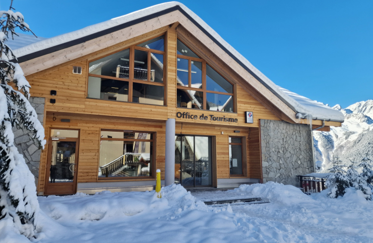 Facade de l'Office de tourisme enneige sous un ciel bleu