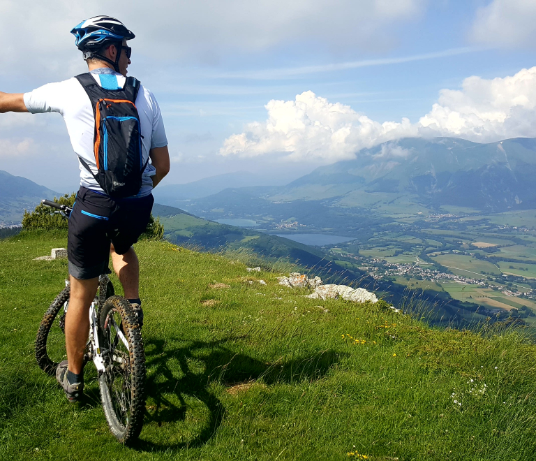 Sportif au sommet d'un sentier VTT et vue sur le plateau matheysin